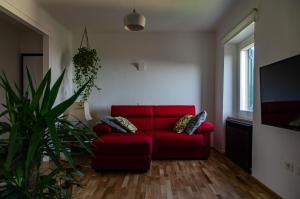 雷卡纳蒂Finestra sul mare的客厅配有红色沙发和植物