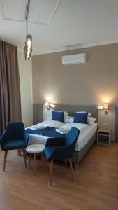 巴拉通马里亚弗都纳普苏格酒店的一间卧室配有两张床和两张蓝色椅子
