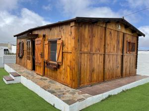 拉拉古纳Agradable Mini Casa de madera con jardín amplio的草上带门窗的木结构建筑