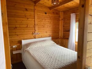 拉拉古纳Agradable Mini Casa de madera con jardín amplio的小木屋内一间卧室,配有一张床
