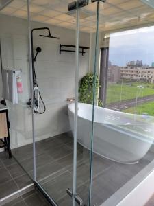头城伊莱屋民宿的带浴缸和玻璃淋浴间的浴室。
