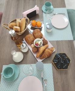 萨林德吉罗les chambres du Saunier的一张桌子上放着一盘糕点和面包