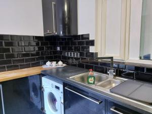 克罗伊登Apartment & Rooms in London的厨房配有洗衣机和水槽
