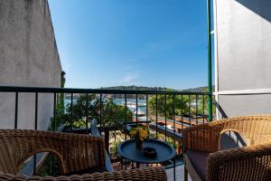尼亚卢卡Hotel Dalmacija的阳台配有2把椅子和1张桌子,享有风景。