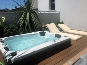 卡奥莱Ninfea Wellness & Spa Residence的甲板上配有热水浴缸和两把椅子