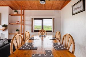 斯特兰拉尔Lodge Cabin with Fabulous Views - Farm Holiday的一间带木桌和椅子的用餐室