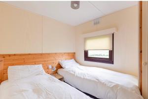 斯特兰拉尔Lodge Cabin with Fabulous Views - Farm Holiday的带窗户的客房内的两张床