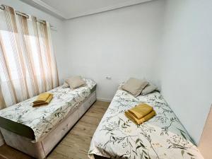 坎佩略Sunny Escape in El Campello的一间卧室设有两张床和窗户。