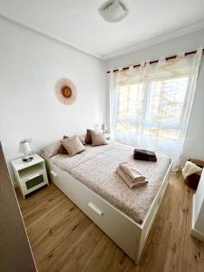 坎佩略Sunny Escape in El Campello的白色卧室设有一张大床和窗户