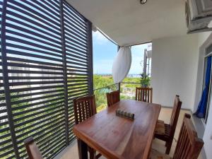 迪亚尼海滩Aqua Resort的一间带木桌和大窗户的用餐室