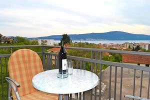 蒂瓦特Tivat Apartments的阳台上的桌子上摆放着一瓶葡萄酒
