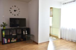派尔努Rääma Apartment的客厅配有电视和墙上的时钟