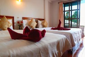 拉迈邦尼酒店的宿舍间内的两张床,配有红色枕头