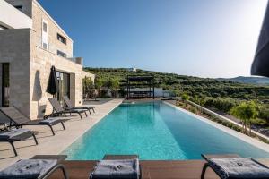 基萨莫斯Villas Phos and Kallos的庭院内一个带躺椅的游泳池