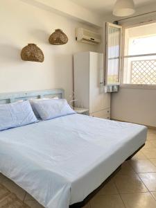马尔扎梅米Diga Rooms的卧室设有一张白色大床和一扇窗户。