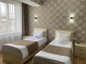 NinotsmindaHotel Sharl的一间卧室设有两张床和窗户。