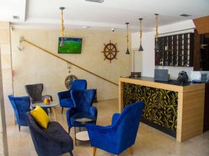 布德瓦Hotel Palma Jaz Budva的一间设有蓝色椅子的等候室和一间酒吧