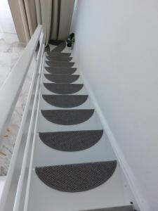 波利克罗诺Nefeli Seaside Apartments的白色房间中带黑色跑步道的楼梯