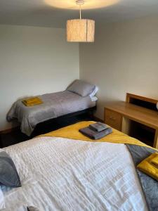 皮耶罗沃尔2 Bedroom house overlooking Pierowall Bay, Westray的一间卧室配有两张床、一张桌子和一盏灯。
