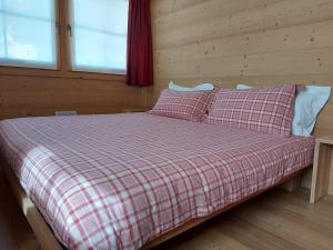 瓦尔迪登特罗Chalet Taulei的一张床上,床上有铺垫的毯子和枕头