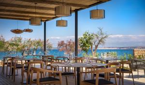 普莱克DUNATOVI DVORI Heritage Hotel的一间设有桌椅并享有水景的餐厅
