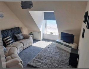 坎贝尔城Inviting 1-Bed Apartment in Campbeltown Loch views的带沙发和电视的客厅