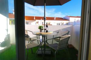 阿尔布费拉Albufeira Central Apartment, 10 mins walk to beach的阳台配有桌椅和遮阳伞