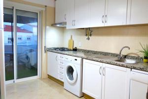 阿尔布费拉Albufeira Central Apartment, 10 mins walk to beach的厨房配有洗衣机和水槽