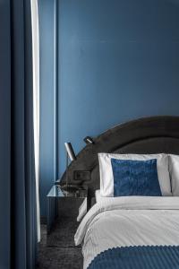 考纳斯Berman House的蓝色的卧室,配有床和玻璃桌