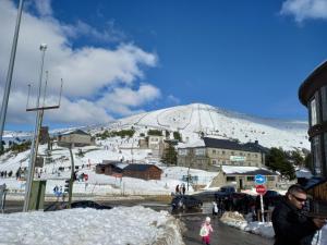 BustarviejoCasa de huéspedes Villa de las Hortensias的站在雪覆盖的山前的街道上的人