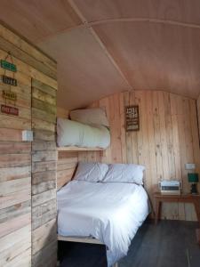 Upper Elkstoneorchard meadow shepherd huts leek-buxton-ashbourne的木墙客房的一张床位
