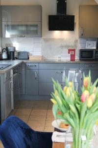 圣温德尔Ferienhaus CLARNI的厨房配有蓝色橱柜和植物桌子