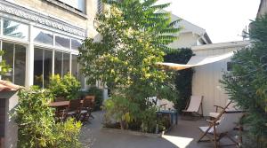 波尔多B&B La Halte Montaigne的一个带桌椅和树的庭院