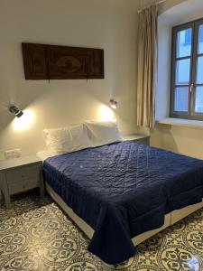 伊兹拉Mercato Vecchio House的一间卧室设有蓝色的床和窗户。