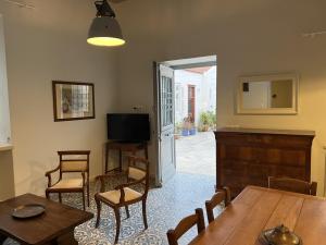 伊兹拉Mercato Vecchio House的一间带桌椅和电视的用餐室