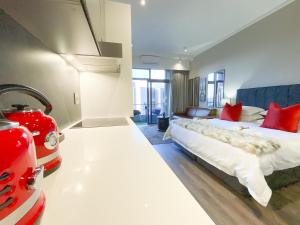 比勒陀利亚Menlyn Maine Residences - Paris king sized bed的一间卧室配有一张带红色枕头的大床