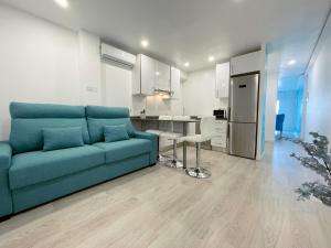 罗列特海岸Happy LLoret的一间带蓝色沙发的客厅和一间厨房