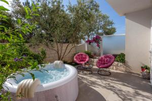 赫瓦尔佩拉公寓的后院设有热水浴池和2把粉红色的椅子