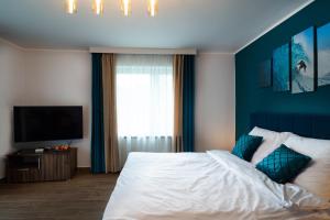 BrwinówApartament Zielony Przylądek的一间卧室配有一张蓝色墙壁的床
