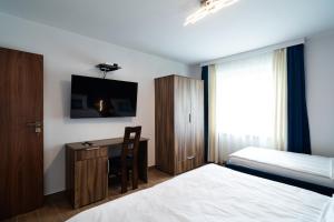 BrwinówApartament Zielony Przylądek的酒店客房配有一张床和一张书桌及一台电视