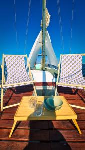 奥良Sirius - Boat House的船上的一张桌子和两把椅子