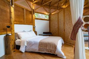 乔阿奇Chalets HUITACA的卧室配有一张床铺,位于带木墙的房间内