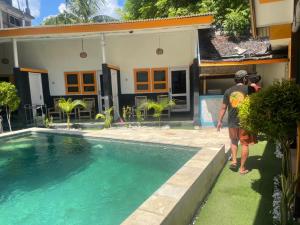 吉利特拉旺安Club Resort MATAHARI的两人站在一座带游泳池的房子前