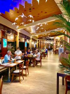 卡伦海滩Baan Sailom Hotel Phuket - Sha Extra Plus的一群坐在餐厅桌子上的人