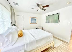 亨博尔Boho Chic的卧室配有白色的床和吊扇