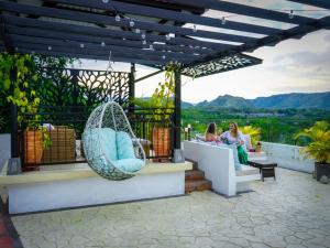 亨达Honda Colonial Magdalena Resort的两名妇女坐在带秋千的庭院