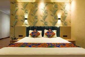 kolkataFabHotel Clive Regency Lovelock的一间卧室配有一张带花卉壁纸的大床