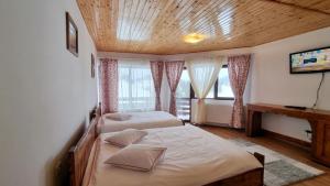 丰达塔La Vulturi的一间卧室设有两张床和木制天花板
