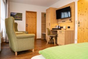 SorgeHotel und Berggasthof Zum Sonnenhof的酒店的客房配有电视、书桌和椅子。