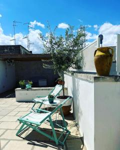 莱切beddhra mia的一个带椅子和桌子的庭院和一个花瓶